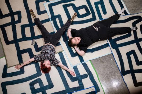  在一场艺术展览中，两名大学生在高空制作“雪天使”，并在艺术迷宫毯子上休息. 
